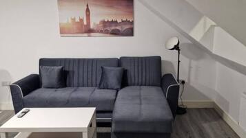 A modern living room with a sofa, a coffee table, and a lamp.