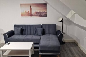 A modern living room with a sofa, a coffee table, and a lamp. - Sav Apartments Nottingham Road Loughborough - 1Bed (Leicestershire)