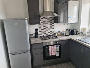A modern kitchen with a built-in oven, a gas stove, and a stainless steel refrigerator. - Sav Apartments Nottingham Road Loughborough - 1Bed (Leicestershire)