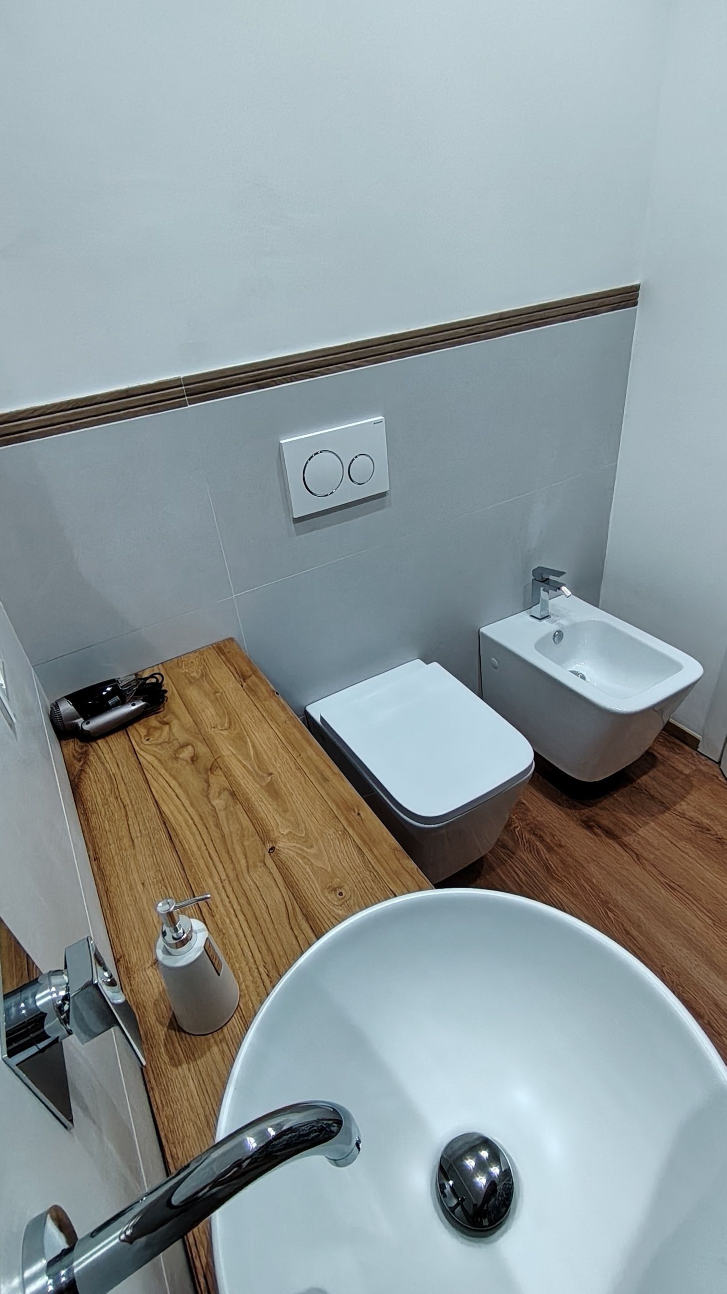 Ein Badezimmer mit einem weißen Waschbecken, einem Bidet und einer Toilette.