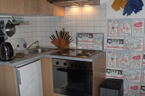 A kitchen with a stove, oven, sink, and various utensils. - Holiday apartment with 1 bedroom (Borkum)