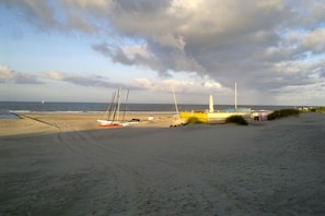 A beach with a sandy shore, a yellow boat, and a sailboat. - Holiday apartment with 1 bedroom (Borkum)