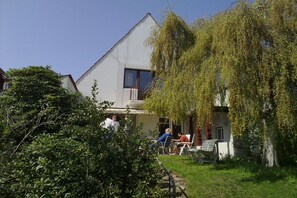 A residential building with a sloped roof, a visible window, and a balcony. - Villa Renate on the North Sea (Cuxhaven)
