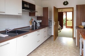 A modern kitchen with white cabinets, a stainless steel sink, and a coffee maker. - "To the Sunflower"||Borkum (Borkum)