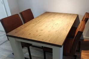 A rectangular dining table with four chairs, a white base, and a wooden top. - ||--------------------House at Domburg----------------|| (Domburg)