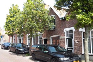 A row of brick houses with parked cars on the street. - ||--------------------House at Domburg----------------|| (Domburg)