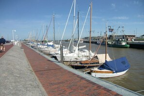 A marina with boats docked along a brick walkway. - Holiday home with 1 bedroom (Bensersiel)