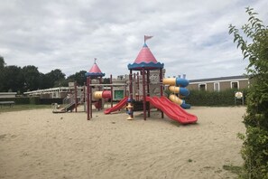 Ein Spielplatz mit Rutsche und Klettergerüsten.