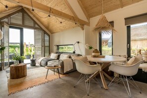 Et moderne interiør med et spiseområde, en sofa og et stort vindue.