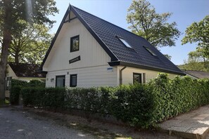 Un bâtiment doté d’un toit à pignon, d’une enseigne indiquant « Leewerk » et d’une haie devant l’entrée.