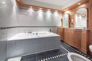 A modern bathroom with a freestanding bathtub, a vanity with a mirror, and a toilet. - Georgian Elegance in Islington, by Veeve (London)