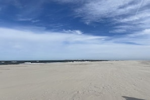 A wide sandy beach with a clear sky and ocean in the distance. - Holiday apartment in Juist with swimming pool (Juist)