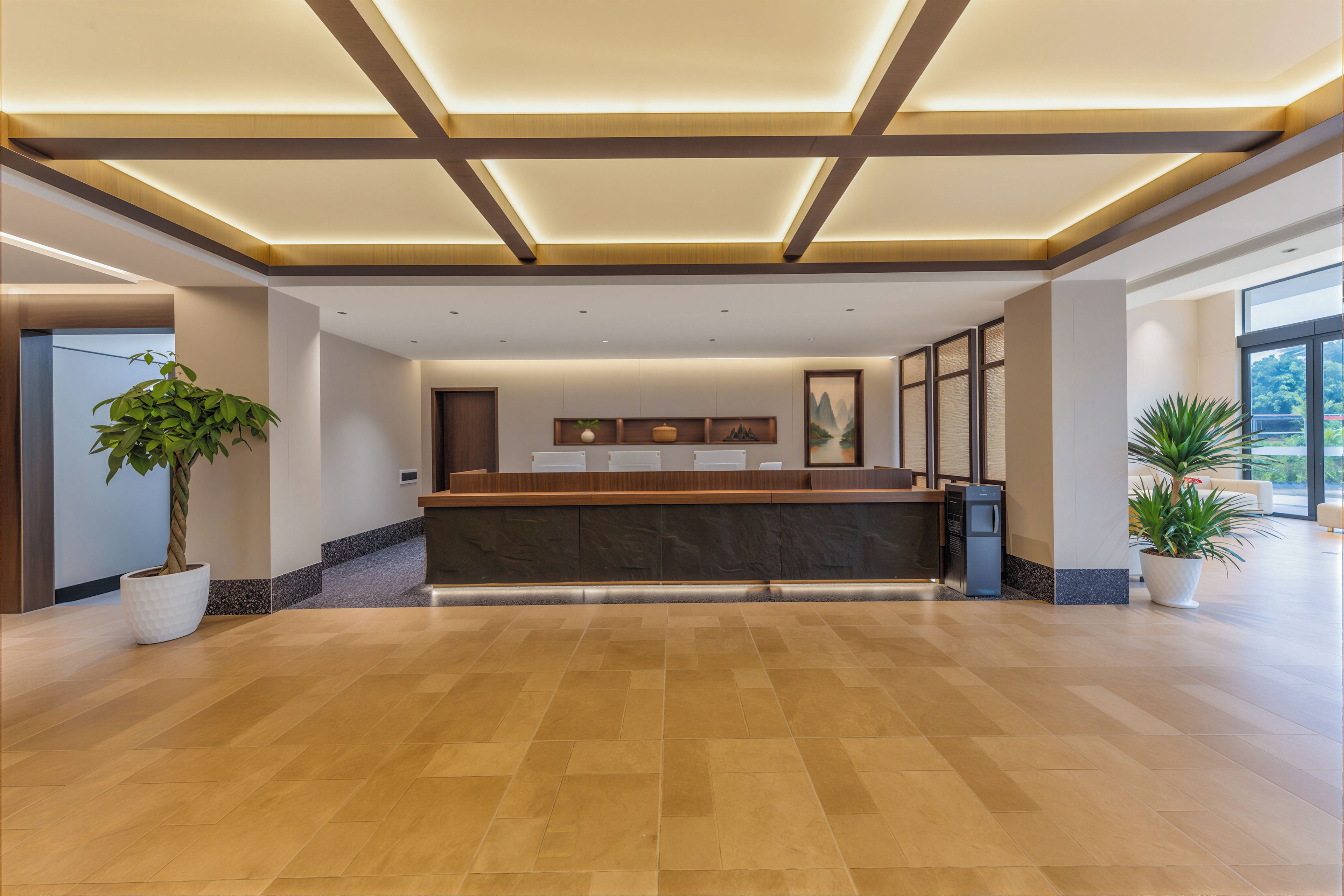 A reception area with a wooden reception desk, potted plants, and a large window providing a view of the outdoors.
