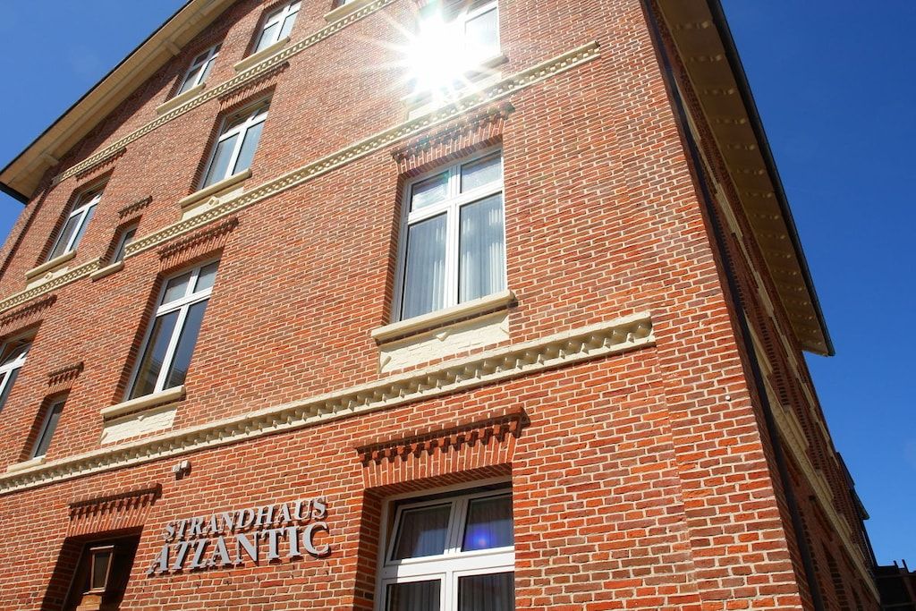 A brick building with the name 'Strandhaus Atlantic' visible on the facade.
