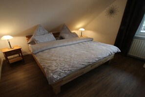 A bedroom with a bed, two bedside tables, and a window. - Holiday apartment with 1 bedroom (Rhauderfehn)