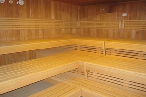 Un sauna avec des bancs en bois et des dossiers à lattes.