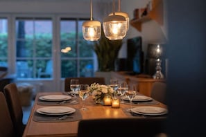 A dining table set for six with candles, glasses, and cutlery. - Holiday apartment with 3 bedrooms (Dangast)