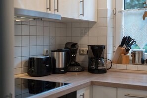 Eine Küche mit Toaster, Kaffeemaschine und einem Schneidebrett auf der Arbeitsfläche.