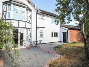 A residential property with a corner house, a paved patio, and a brick wall. - The Annex at The Lodge (Shrewsbury)