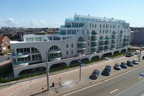 A modern building with multiple balconies and a parking lot. - Holiday apartment in Koksijde with Wi-Fi (Koksijde)