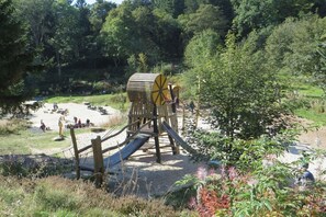 Ein Spielplatz mit einer Holzkonstruktion und einer Rutsche.