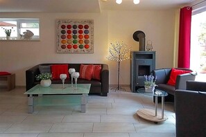 Ein modernes Wohnzimmer mit Sofa, Couchtisch und Kamin.