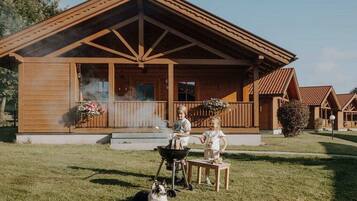 Eine Holzhütte mit Veranda, Grill und Hund.