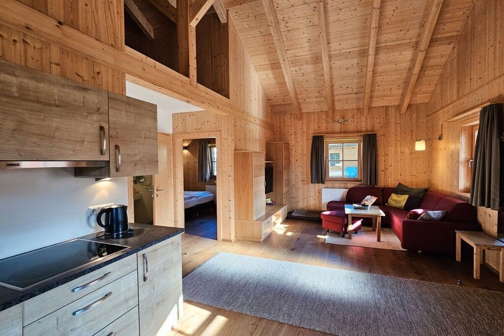 Ein Holzinnenraum mit Küche, Essbereich und Wohnzimmer.