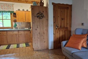 A wooden kitchen with cabinets, a sink, and a window with a view. - Holiday home with 1 bedroom (Unterach am Attersee)