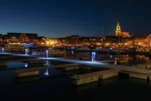 A waterfront area with buildings, a prominent tower, and a marina with boats. - Holiday apartment in Waren with swimming pool (Waren)