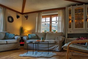 A cozy living room with a sofa set, a coffee table, and a cabinet with glass doors. - Holiday apartment with 2 bedrooms (Trebesing)