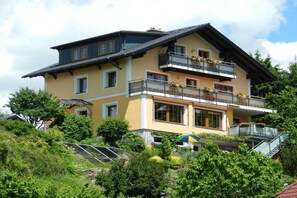 Un immeuble à plusieurs étages, doté de balcons, de grandes fenêtres et d’un toit en pente.