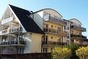 A multi-story residential building with balconies, a flat roof, and a clear sky. - Holiday apartment directly on the beach (Ostseebad Baabe)