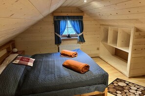 Una habitación con una cama, una ventana con cortinas y una estantería de madera.