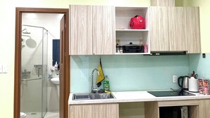 Uma cozinha compacta com pia, micro-ondas e armários de madeira.