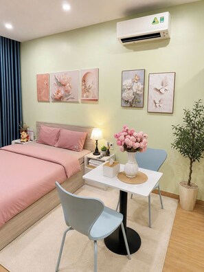 Quarto com cama, mesa de cabeceira, luminária, cadeira e planta em vaso.