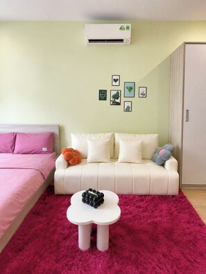 A bedroom with a bed, a sofa, a small table, and a wardrobe. - Cami's Homestay (An Bien)
