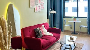 Uma sala de estar moderna com um sofá vermelho, uma mesa pequena e um espelho.