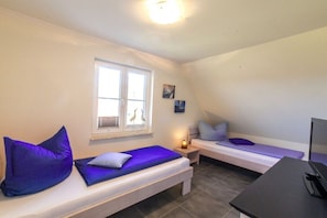 A room with two beds, a desk, and a window with a view of birds. - Dreamcatcher "Dreaming under thatch" (Rerik)