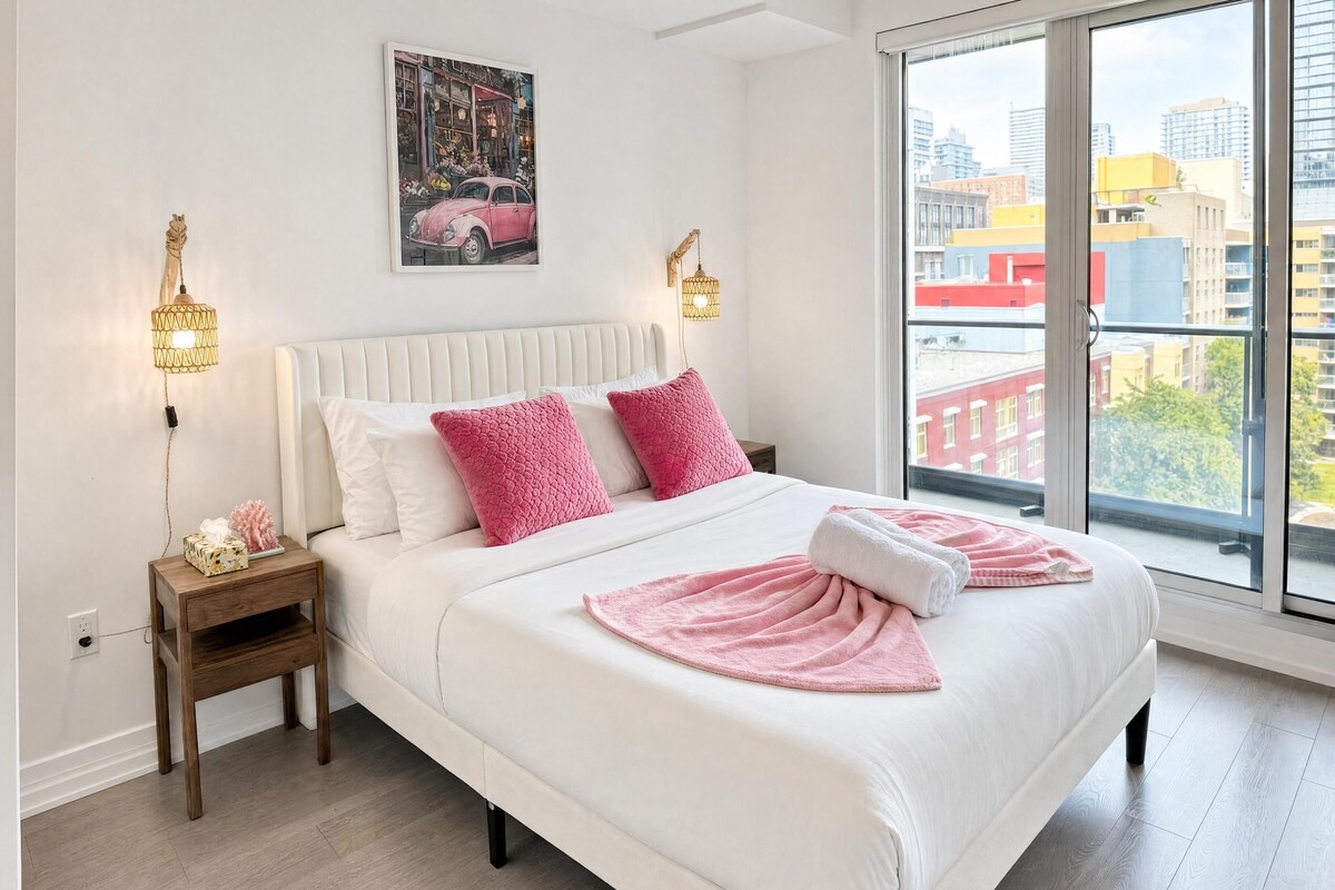 Habitación de hotel con una cama grande, vistas a la ciudad y un cuadro en la pared.
