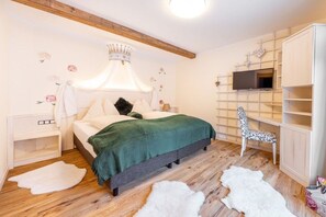 Ein Schlafzimmer mit Bett, Fernseher, Kleiderschrank und Stuhl.
