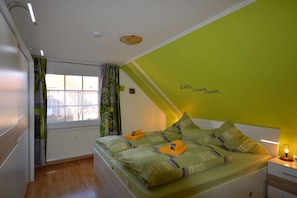 Ein Schlafzimmer mit einem Bett, einem Fenster und einer Wand mit einem Text.