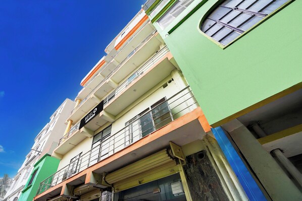 A multi-story hotel building with balconies and a sign indicating it is a hotel.