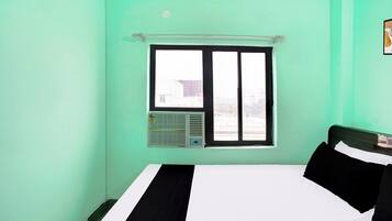 Una habitación con cama, ventana y aire acondicionado.