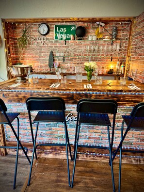 A bar area with a brick wall, a clock, and a sign pointing to Las Vegas.