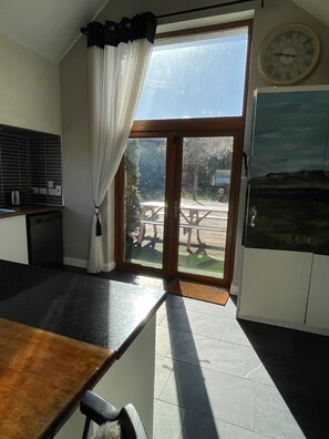 A kitchen with a sliding glass door leading to an outdoor patio area.