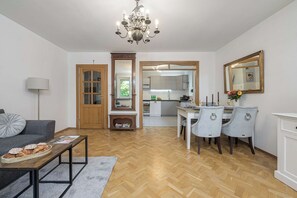Ein modernes Wohnzimmer mit einer Couch, einem Couchtisch und einem Essbereich mit Stühlen und einem Tisch.