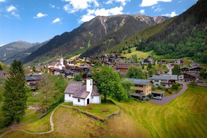 A mountainous village with traditional buildings, a church, and a clear sky. - Penthouse suite with outdoor sauna (Gaschurn)