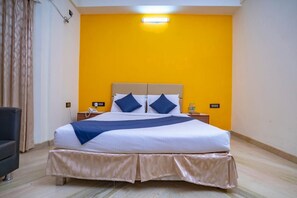 A hotel room with a bed, bedside tables, a telephone, and a nightstand. - SS Mansion by AZM Residences Luxury 3BHK  3 En Suite AC Bedrooms Fully Furnished (Bengaluru)