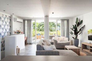 Ein modernes Wohnzimmer mit einer Couch, einem Couchtisch und einem Fernseher auf einem Holzboden.